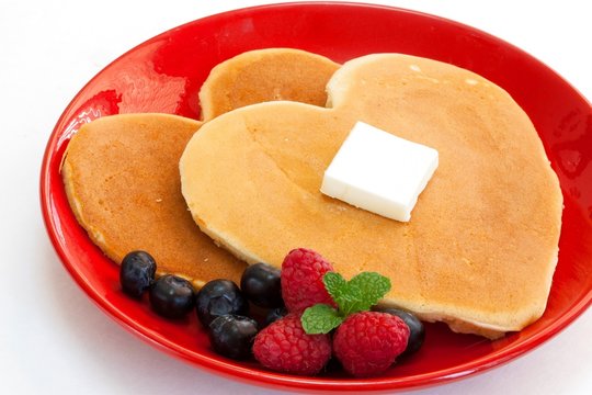 Heart shaped pancakes on white background