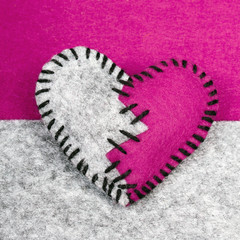 stitched broken felt heart on a on a two-color background