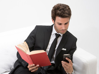 Uomo su Divano con Cellulare e Libro