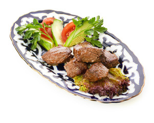 Meat on a grill with vegetables