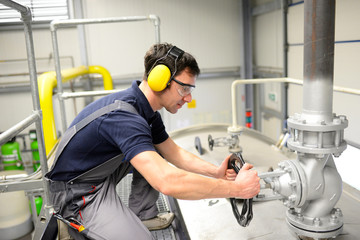 Industriearbeiter bedient Ventil // worker operating