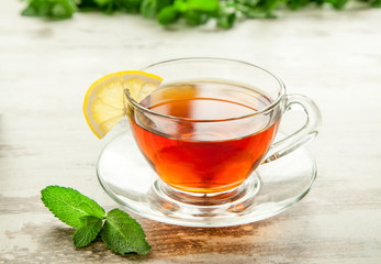 Glass cup of tea on a wooden table.