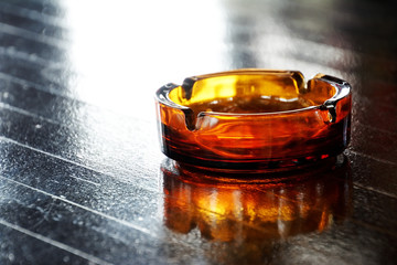 Glass ashtray on wooden table