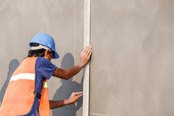 plasterer concrete worker at wall of house construction