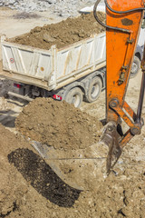 excavator arm with bucket full of dirt