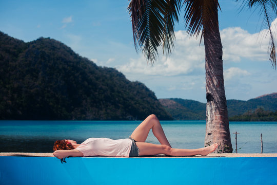 Young woman relaxing by swimming pool