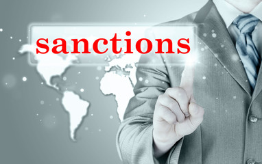 businessman pressing sanctions button on virtual screens
