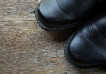 Fototapeta na wymiar A pair of black shoes close up on wood background.