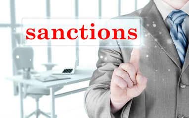 businessman pressing sanctions button on virtual screens