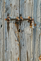 Portone vecchio in legno con chiavistello arrugginito