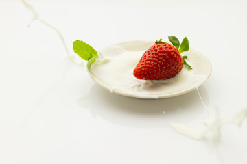 strawberry falling into cream