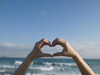 Women who are making the shape of a heart in hand