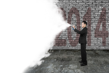 Businessman spray white cloud covering old 2014 dark brick wall