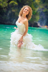 Fototapeta na wymiar blonde bride stand in seawater