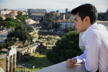 Fototapeta na wymiar Serious Man on Terrace Looking at Outdoor View in Rome, Italy