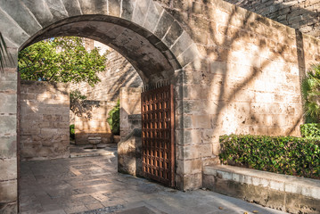 Fototapeta na wymiar Arched entrance with a wooden gate in Palma de Majorca
