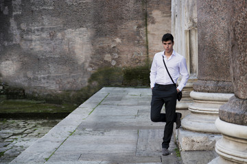 Handsome young man outdoor next to ancient marble columns