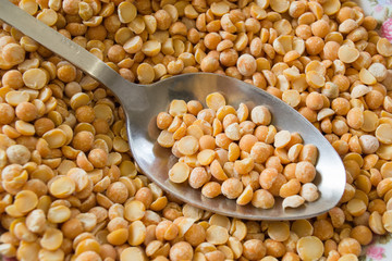 Background yellow peas with an iron spoon