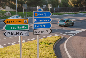 Various Road Direction Signs on a Small Grassland at the Street