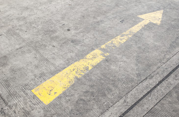 yellow way arrow pointing in directions symbol on a ground road