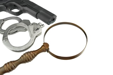 Gun, Handcuffs and Magnifying Glass Isolated on White Background