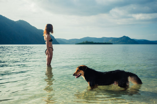 Woman with dog on tropical beach