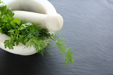 Dill and parsley in a marble mortar
