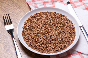 close up of buckwheat in plate with fork and knife