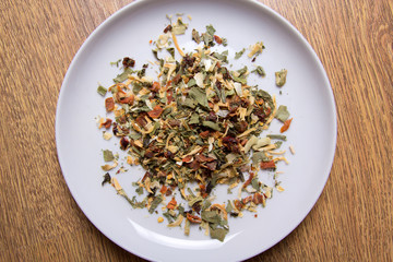 close up of spices mixed in plate on wooden table