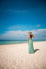 Fototapeta na wymiar Girl walking along a tropical beach in the Maldives.