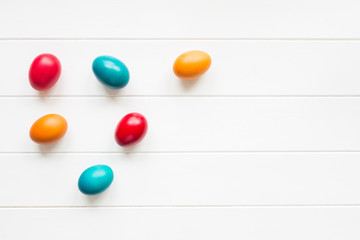 Easter eggs arrangement on white wooden background, top view
