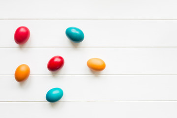 Easter eggs arrangement on white wooden background, top view