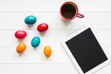 Top view of easter eggs morning arrangement with tablet device