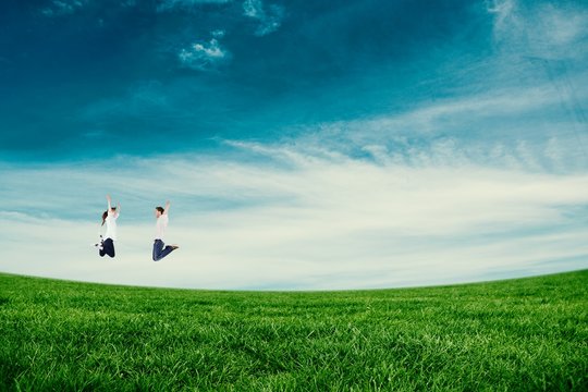 Composite image of couple jumping in the air