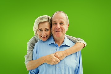 Happy mature couple embracing smiling at camera