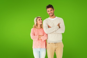 Composite image of attractive couple smiling with arms crossed