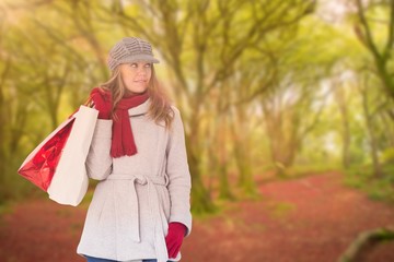 Composite image of happy blonde in winter clothes with bags