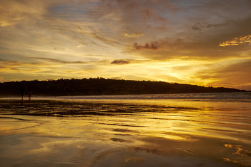 silhouettes of couples on the beach in sunset