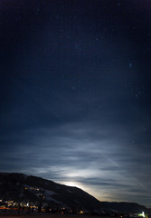 mountain silhouette against starry nigh sky and shining moon