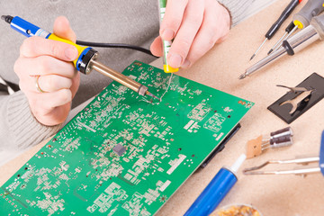 Serviceman soldering on PCB
