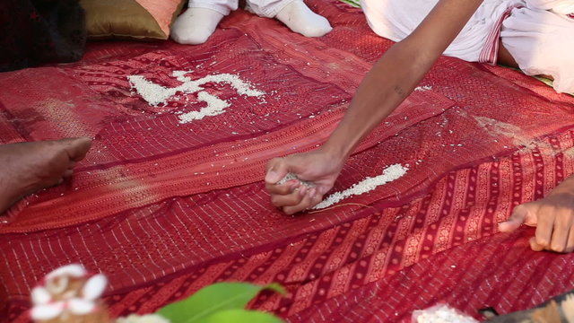 hindu brahmin conducting indian wedding ceremony making swastika