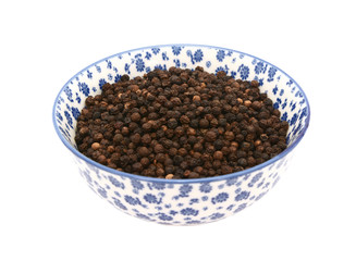 Black peppercorns in a blue and white china bowl