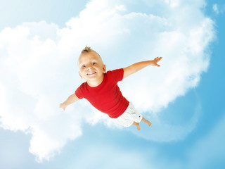 Obraz premium Little boy flying up into the blu sky