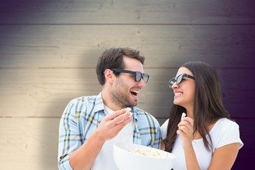 Composite image of attractive young couple watching a 3d movie