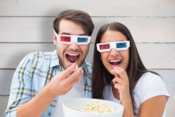 Composite image of attractive young couple watching a 3d movie