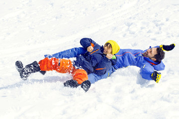 little boy and his father sledding very fast