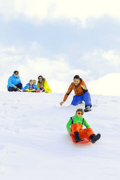 Family Sledding In Winter