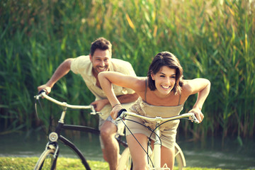Couple having a bicycles race into the nature