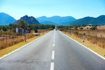 Highway road with mountains on horizon