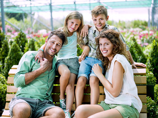 family having fun with in a greenhouse